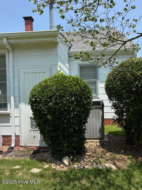 908 E 7th St, Lumberton, NC 28358 - view of side of property with a cooling unit and a chimney
