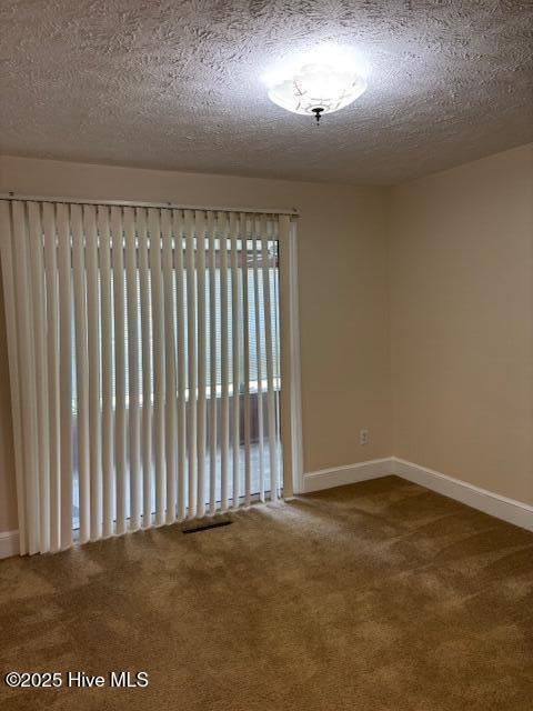 908 E 7th St, Lumberton, NC 28358 - unfurnished room with carpet flooring and a textured ceiling