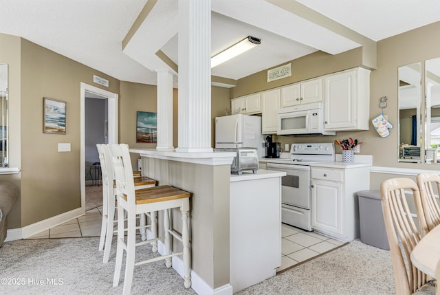 330 S Middleton Dr NW Unit 1201, Calabash, NC 28467 - kitchen with ornate columns, white appliances, light tile patterned floors, and white cabinets