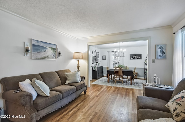 1409 Knollwood Dr NW, Wilson, NC 27896 - living area with a chandelier, hardwood / wood-style floors, a textured ceiling, ornamental molding, and baseboards