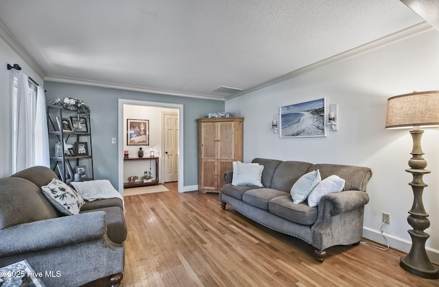 1409 Knollwood Dr NW, Wilson, NC 27896 - living room featuring light wood-style flooring, crown molding, baseboards, and a textured ceiling