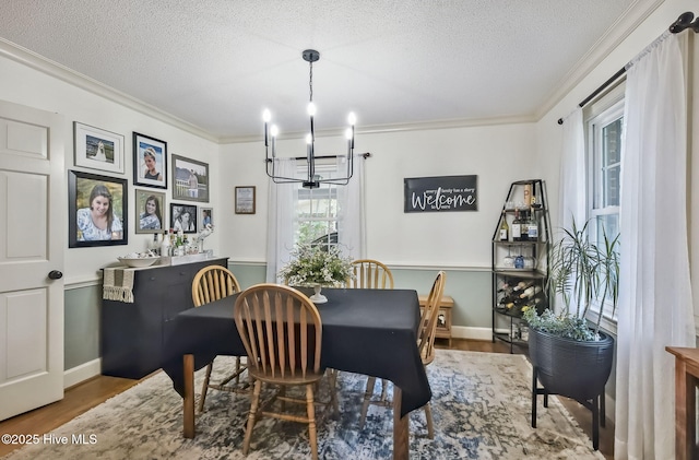 1409 Knollwood Dr NW, Wilson, NC 27896 - dining space featuring a chandelier, ornamental molding, wood finished floors, a textured ceiling, and baseboards