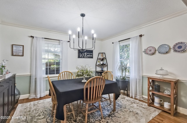 1409 Knollwood Dr NW, Wilson, NC 27896 - dining space featuring a chandelier, ornamental molding, a textured ceiling, wood finished floors, and baseboards
