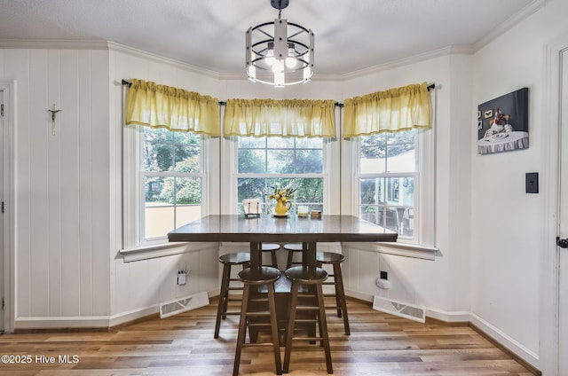 1409 Knollwood Dr NW, Wilson, NC 27896 - dining space with plenty of natural light, wood finished floors, crown molding, and a chandelier