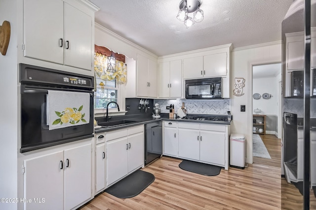 1409 Knollwood Dr NW, Wilson, NC 27896 - kitchen with black appliances, a sink, dark countertops, white cabinetry, and a textured ceiling
