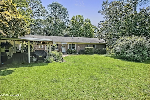 1409 Knollwood Dr NW, Wilson, NC 27896 - rear view of house with a yard, central air condition unit, brick siding, and a chimney