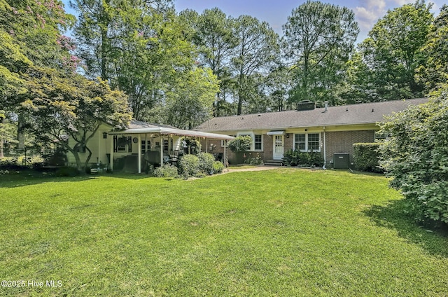 1409 Knollwood Dr NW, Wilson, NC 27896 - back of property with a lawn, brick siding, a chimney, and central AC unit