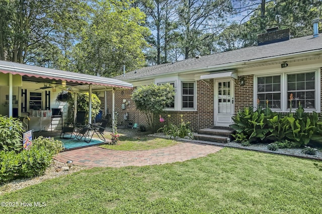 1409 Knollwood Dr NW, Wilson, NC 27896 - doorway to property featuring a yard, brick siding, a chimney, a patio area, and ceiling fan