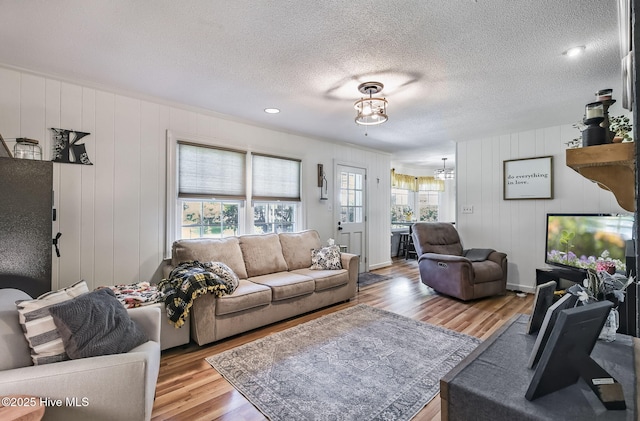 1409 Knollwood Dr NW, Wilson, NC 27896 - living area with healthy amount of natural light, wood finished floors, a chandelier, and a textured ceiling