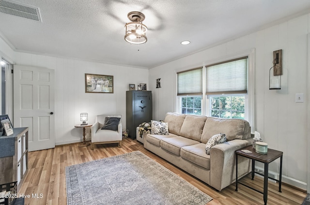 1409 Knollwood Dr NW, Wilson, NC 27896 - living room featuring light wood-type flooring, crown molding, baseboards, and a textured ceiling