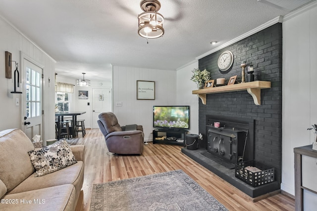 1409 Knollwood Dr NW, Wilson, NC 27896 - living room featuring crown molding, wood finished floors, a fireplace, and a textured ceiling