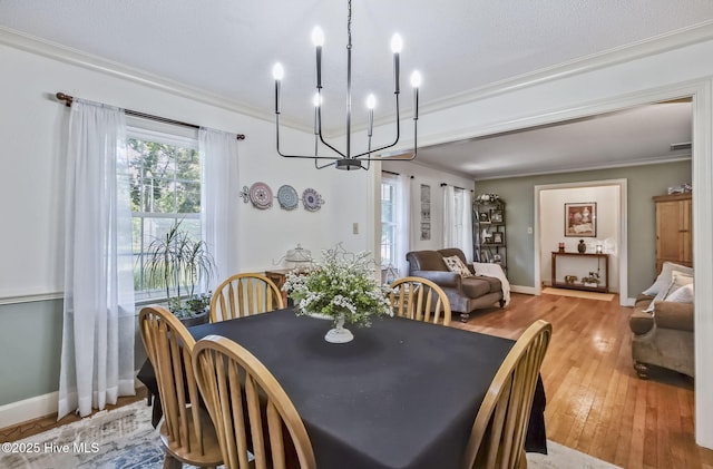 1409 Knollwood Dr NW, Wilson, NC 27896 - dining space with crown molding, a chandelier, light wood-type flooring, and baseboards