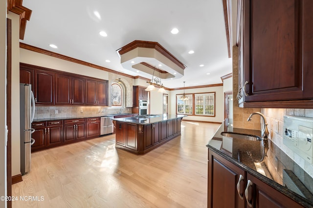 6424 River Vista Dr, Wilmington, NC 28412 - kitchen featuring ornamental molding, stainless steel appliances, a sink, light wood-style floors, and dark stone counters