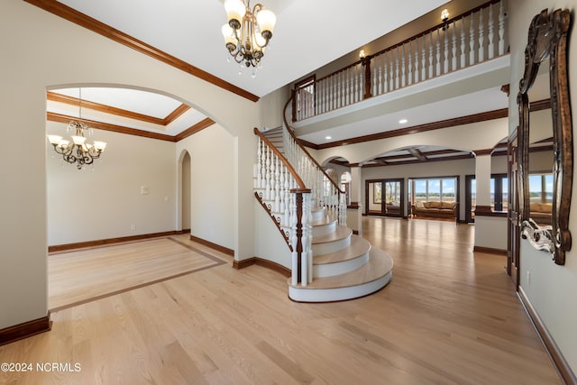 6424 River Vista Dr, Wilmington, NC 28412 - foyer entrance with arched walkways, a chandelier, wood finished floors, stairs, and ornamental molding