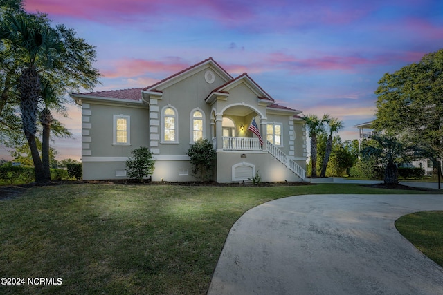 6424 River Vista Dr, Wilmington, NC 28412 - mediterranean / spanish-style home with stucco siding, a front yard, covered porch, stairs, and crawl space
