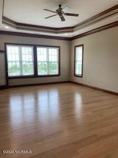 6424 River Vista Dr, Wilmington, NC 28412 - spare room with ornamental molding, wood finished floors, a tray ceiling, baseboards, and a ceiling fan