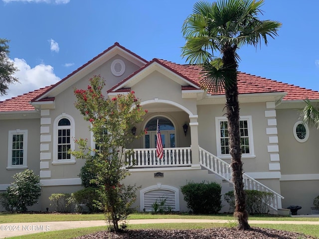 6424 River Vista Dr, Wilmington, NC 28412 - mediterranean / spanish-style house featuring a tiled roof, stairway, stucco siding, and a porch