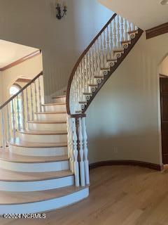 6424 River Vista Dr, Wilmington, NC 28412 - staircase with wood finished floors, baseboards, and arched walkways