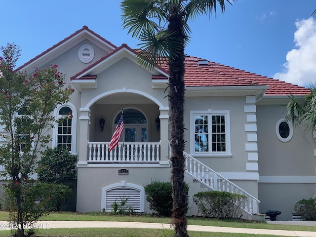 6424 River Vista Dr, Wilmington, NC 28412 - mediterranean / spanish-style house featuring stairway, stucco siding, a porch, and a tiled roof