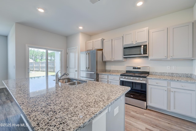 5380 Black Oak Ct, Winnabow, NC 28479 - kitchen featuring stainless steel appliances, light wood-type flooring, light stone countertops, recessed lighting, and a kitchen island with sink