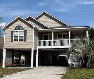 126 NE 5th St, Oak Island, NC 28465 - coastal home with a carport, driveway, and a porch