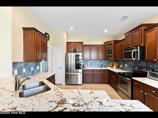1232 Fence Post Ln, Carolina Shores, NC 28467 - kitchen with appliances with stainless steel finishes, a sink, tasteful backsplash, vaulted ceiling, and recessed lighting