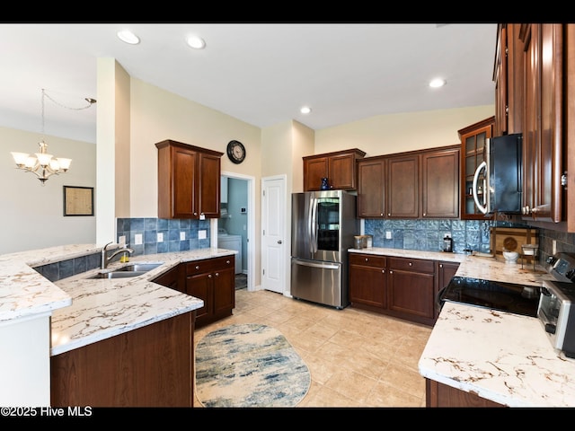 1232 Fence Post Ln, Carolina Shores, NC 28467 - kitchen with smart refrigerator, a sink, a chandelier, tasteful backsplash, and a peninsula
