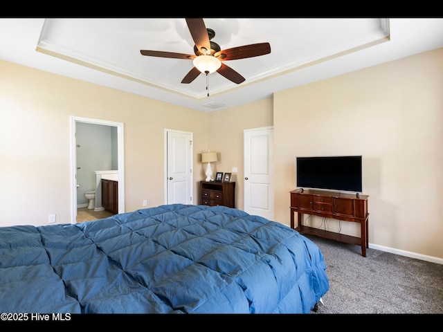 1232 Fence Post Ln, Carolina Shores, NC 28467 - carpeted bedroom featuring a raised ceiling, baseboards, ensuite bath, and ceiling fan