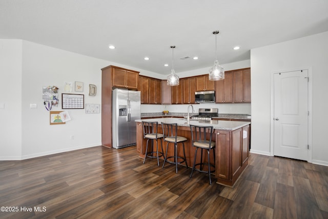 122 Mill Run Loop, South Mills, NC 27976 - kitchen with stainless steel appliances, dark wood-style flooring, recessed lighting, a kitchen breakfast bar, and an island with sink
