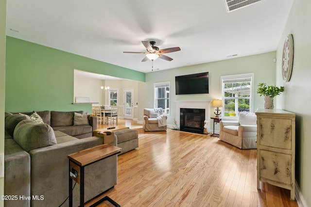 6005 Otter Tail Trl, Wilmington, NC 28412 - living area with ceiling fan, plenty of natural light, light wood-style flooring, and a glass covered fireplace