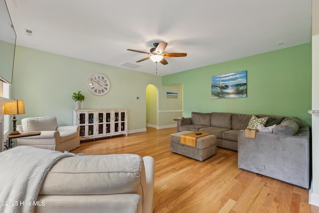 6005 Otter Tail Trl, Wilmington, NC 28412 - living room featuring arched walkways, a ceiling fan, and light wood-style flooring