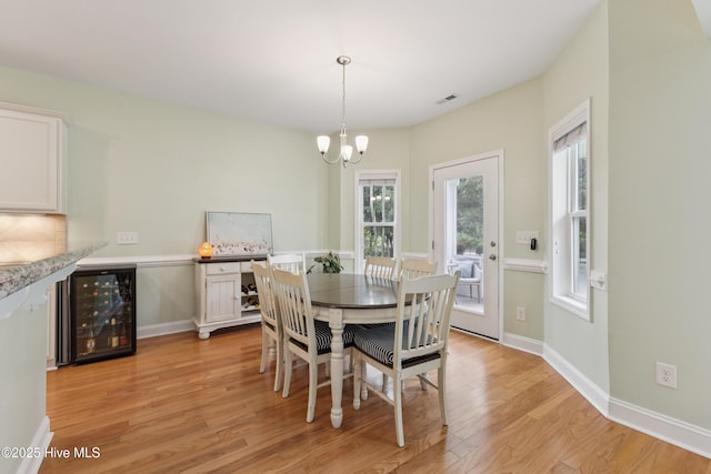6005 Otter Tail Trl, Wilmington, NC 28412 - dining space with wine cooler, light wood-type flooring, a chandelier, and healthy amount of natural light