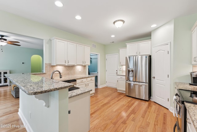 6005 Otter Tail Trl, Wilmington, NC 28412 - kitchen featuring stainless steel appliances, a peninsula, white cabinets, light wood-style floors, and recessed lighting