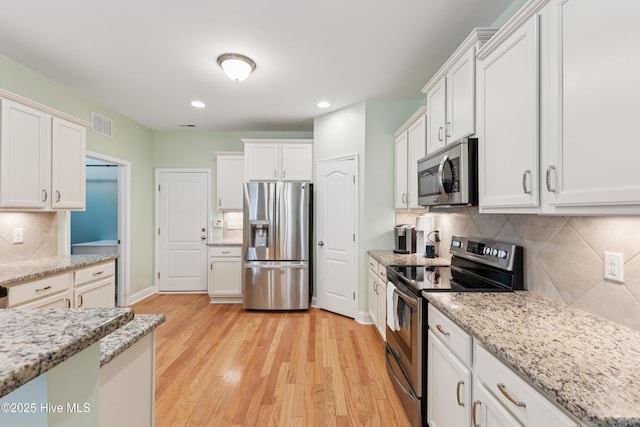6005 Otter Tail Trl, Wilmington, NC 28412 - kitchen with appliances with stainless steel finishes, tasteful backsplash, recessed lighting, white cabinets, and light wood-style flooring