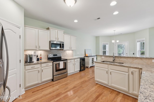 6005 Otter Tail Trl, Wilmington, NC 28412 - kitchen with appliances with stainless steel finishes, tasteful backsplash, light wood-style floors, white cabinets, and recessed lighting