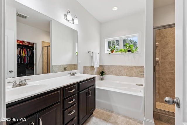6005 Otter Tail Trl, Wilmington, NC 28412 - full bathroom featuring a bath, a stall shower, double vanity, a spacious closet, and tile patterned floors