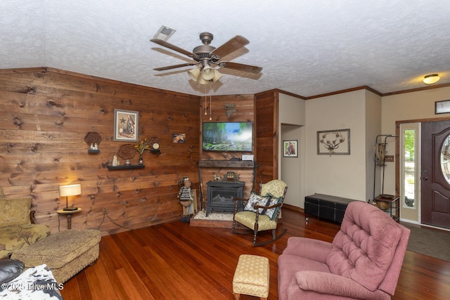 108 Western Trl, Carthage, NC 28327 - living room featuring a wood stove, ceiling fan, wood finished floors, a textured ceiling, and ornamental molding