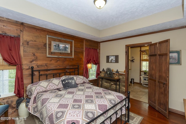 108 Western Trl, Carthage, NC 28327 - bedroom featuring a textured ceiling, dark wood-style floors, baseboards, and wood walls