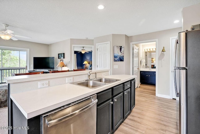 3350 Club Villas Dr # 105, Southport, NC 28461 - kitchen featuring appliances with stainless steel finishes, a sink, a ceiling fan, light wood-style floors, and light countertops