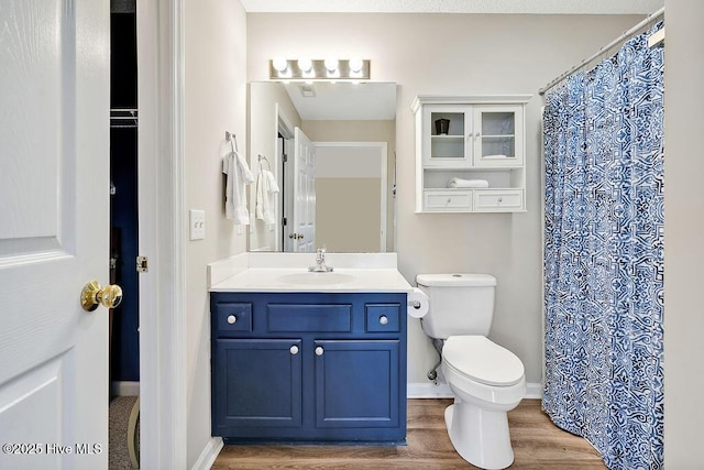 3350 Club Villas Dr # 105, Southport, NC 28461 - full bathroom with vanity, toilet, wood finished floors, and baseboards