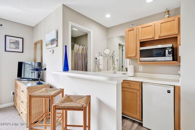 3350 Club Villas Dr # 105, Southport, NC 28461 - kitchen with stainless steel microwave, refrigerator, light countertops, recessed lighting, and baseboards