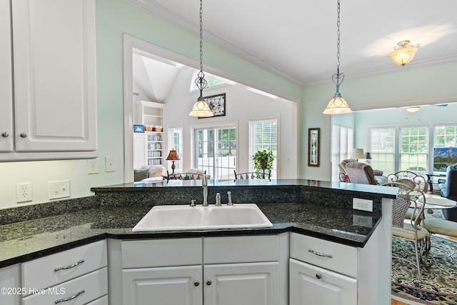 3254 Beaver Creek Dr SE, Southport, NC 28461 - kitchen with open floor plan, a sink, white cabinets, pendant lighting, and crown molding