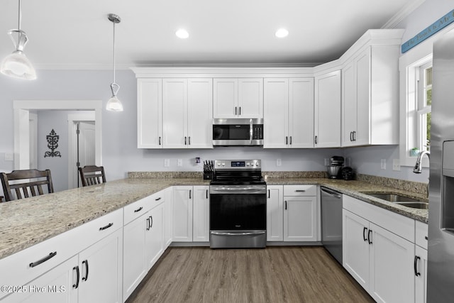 452 Crows Nest Ln, Sneads Ferry, NC 28460 - kitchen with stainless steel appliances, a sink, white cabinets, wood finished floors, and crown molding