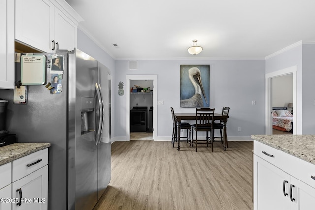 452 Crows Nest Ln, Sneads Ferry, NC 28460 - kitchen with stainless steel fridge with ice dispenser, ornamental molding, light wood-style flooring, white cabinetry, and washer / clothes dryer