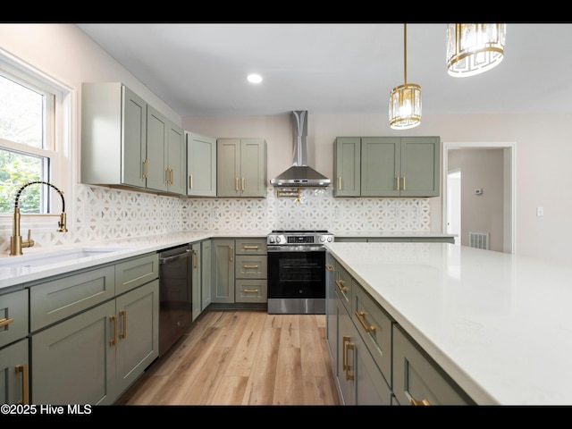 109 Inlet Ct, Hampstead, NC 28443 - kitchen with wall chimney exhaust hood, appliances with stainless steel finishes, a sink, light countertops, and light wood-style flooring