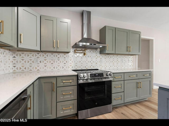 109 Inlet Ct, Hampstead, NC 28443 - kitchen with wall chimney range hood, stainless steel appliances, light countertops, light wood finished floors, and tasteful backsplash