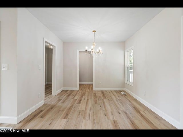 109 Inlet Ct, Hampstead, NC 28443 - empty room with a chandelier, light wood-type flooring, and baseboards