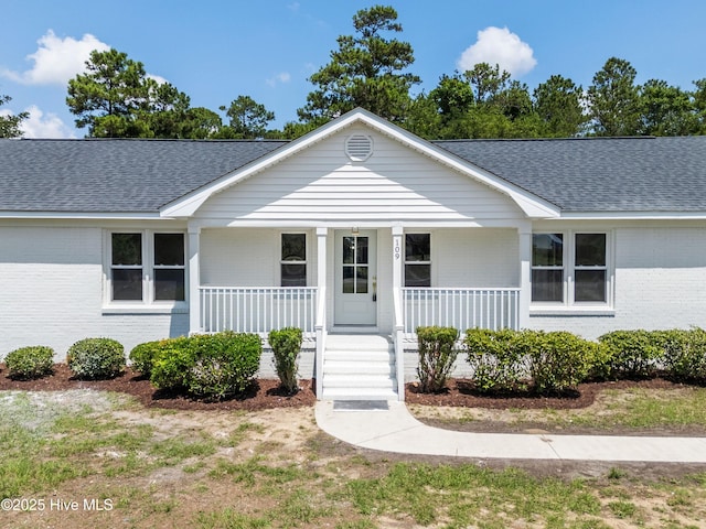 109 Inlet Ct, Hampstead, NC 28443 - view of front of home featuring brick siding, a shingled roof, and covered porch