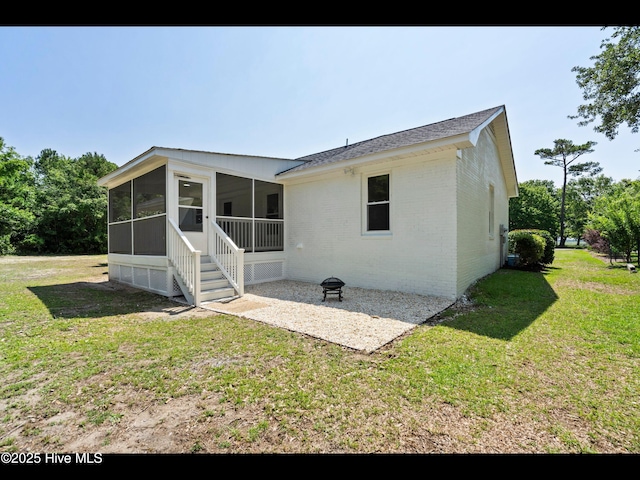 109 Inlet Ct, Hampstead, NC 28443 - rear view of property featuring a sunroom, brick siding, a lawn, a patio area, and a shingled roof