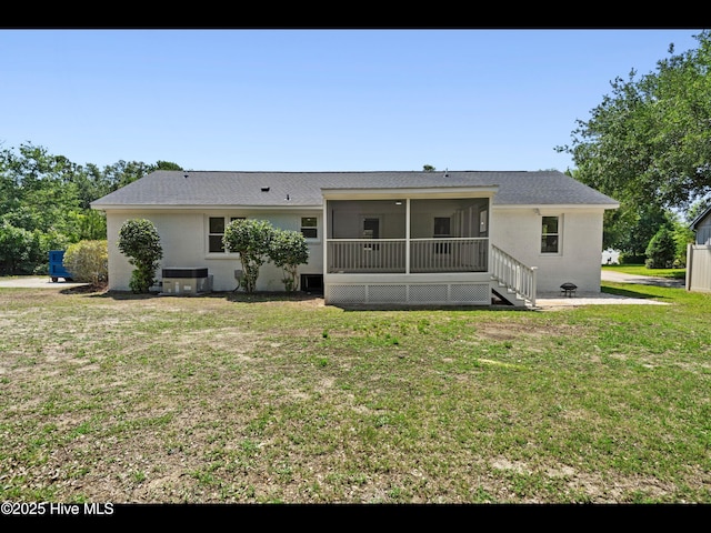 109 Inlet Ct, Hampstead, NC 28443 - back of property with a sunroom, a lawn, cooling unit, a shingled roof, and stucco siding